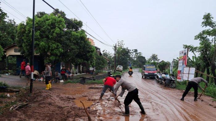 warga membersikan lumpur pasca banjir